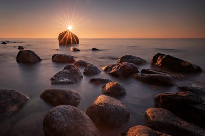 Zachód słońca nad kamienistą plażą (fot. S. Adamczak, okfoto.pl)